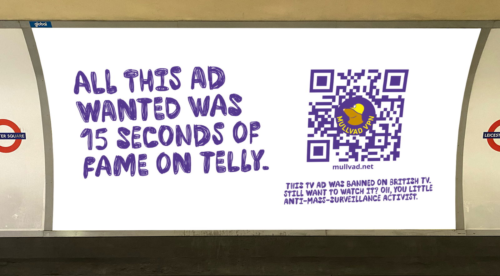 A Mullvad VPN billboard in the London Underground. The sign features a white background with blue, hand-drawn text that reads: 'All this ad wanted was 15 seconds of fame on telly.' To the right is a large blue QR code with the Mullvad logo (a mole in a yellow hat) and the text 'mullvad.net'. Below the QR code, it says: 'This TV ad was banned on British TV. Still want to watch it? Oh, you little anti-mass-surveillance activist.